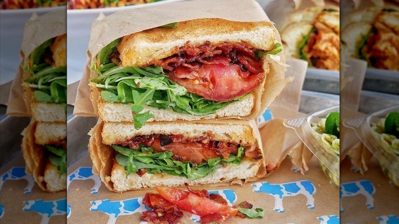 BLT sandwich halves stacked and wrapped in paper