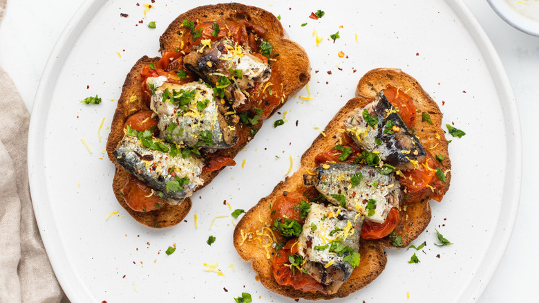 Sardine and tomato toasts on plate