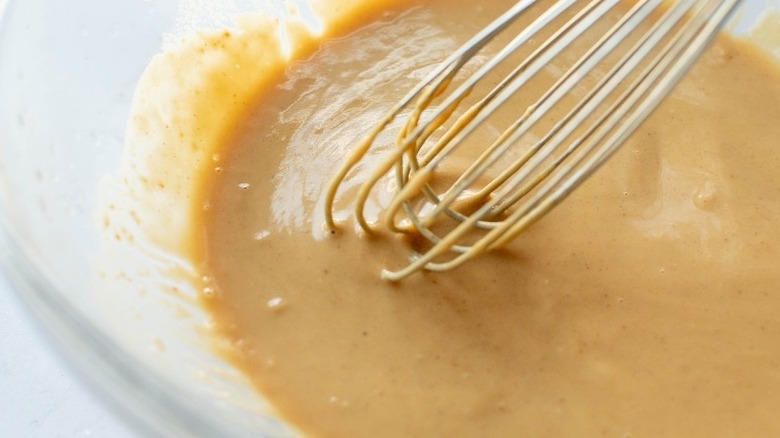peanut butter sauce in bowl with whisk