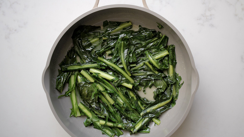 steaming dandelion greens in pan