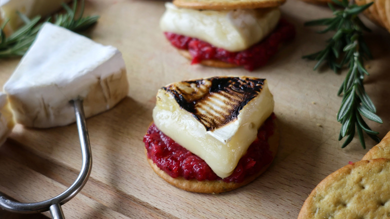 herb cracker topped with cranberry relish and roasted brie