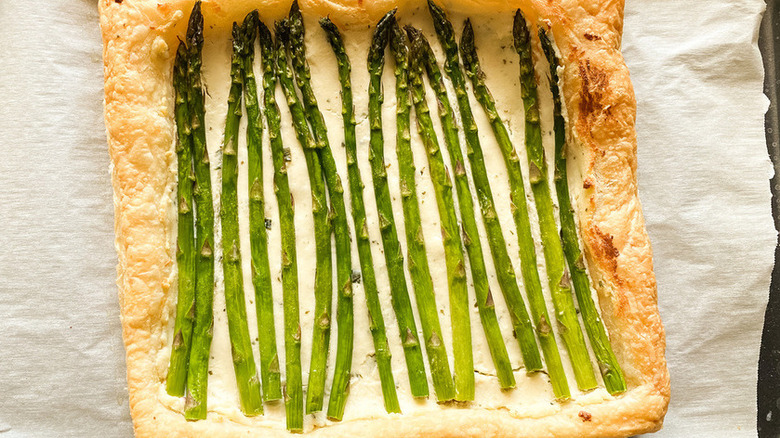 Baked puff pastry tart with asparagus spears.