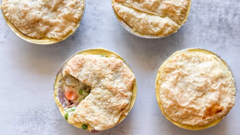 Four small pot pies with creamy chicken filling and crust tops.