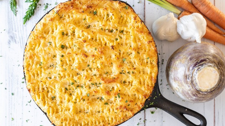 Iron skillet with Baked mashed potato-topped shepherd's pie.