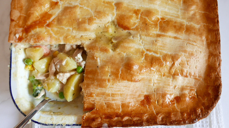 Chicken and veggie filling in pan under browned crust.