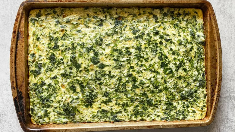 Baked spinach egg pie in baking sheet. 