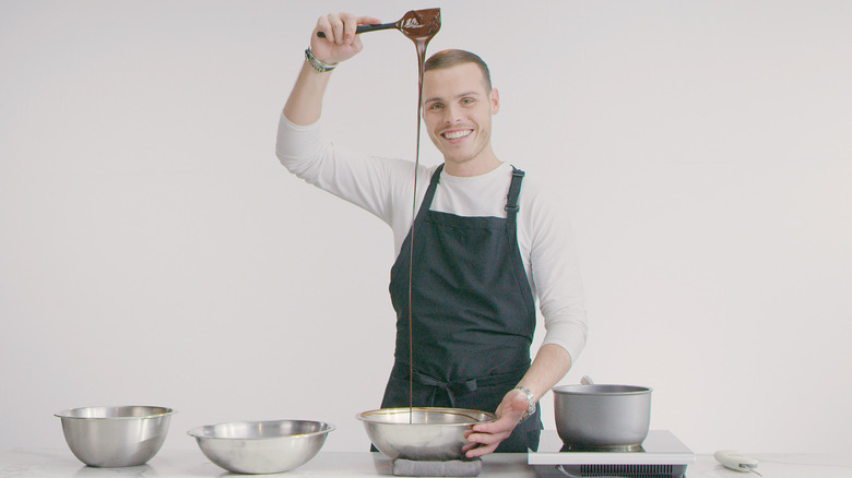 Amaury Guichon holding a spatula with chocolate