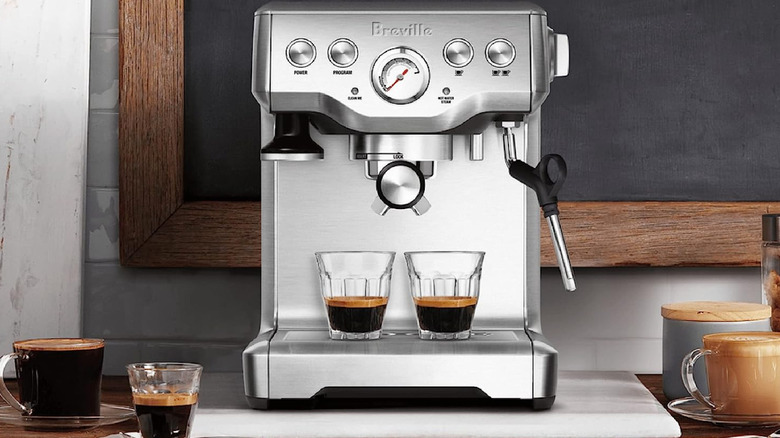 Silver double espresso machine with glasses of espresso.