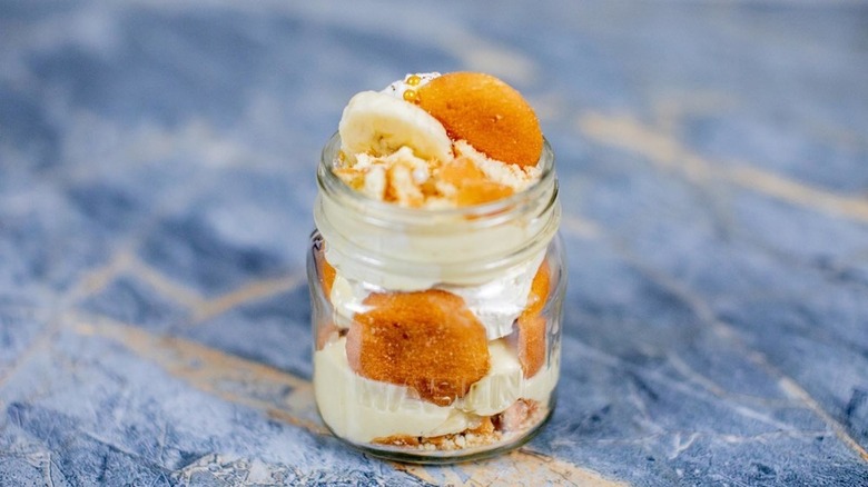 glass mason jar filled with fresh sliced bananas, vanilla wafers and pudding