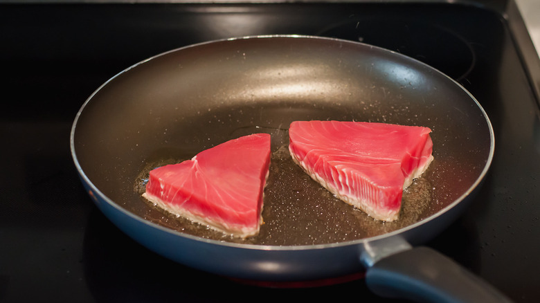 seared tuna steaks in pan cooked on one side
