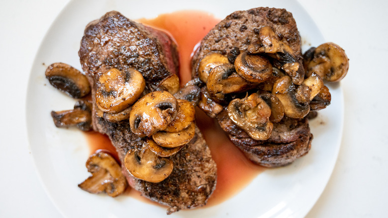 two steaks with sauteed mushrooms