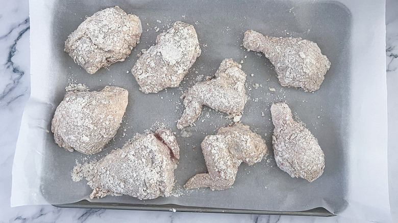 unbaked fried chicken on sheet pan