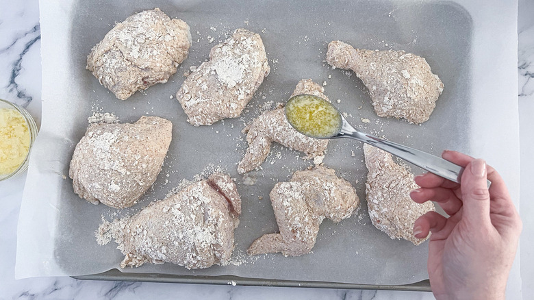 spoon drizzling butter onto chicken