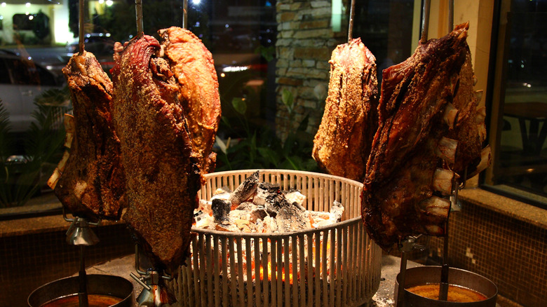 Meat being grilled on vertical stakes