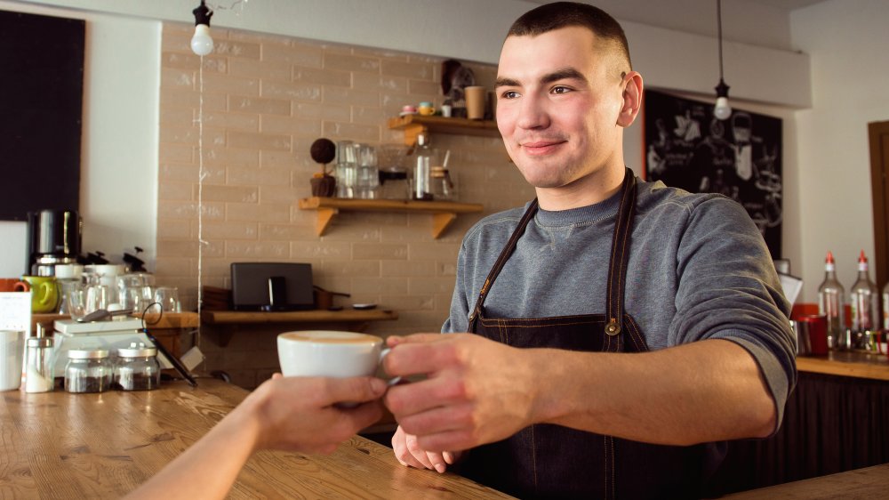 barista handing over coffee