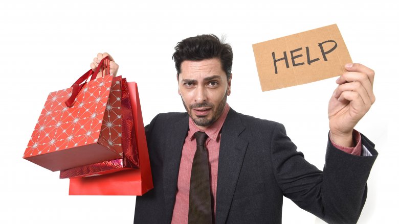 man holding shopping bags and help sign