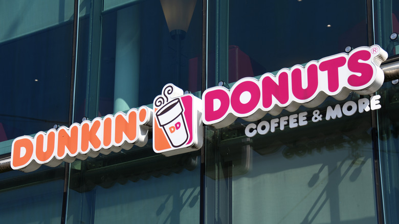 dunkin donuts sign outside of building with lots of windows