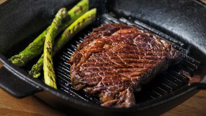 Seared steak on cast iron with asparagus