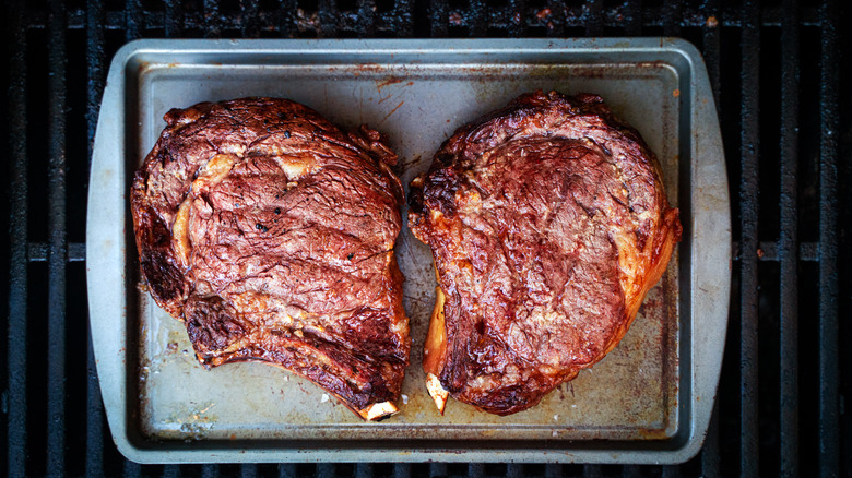 Steaks resting on baking sheet