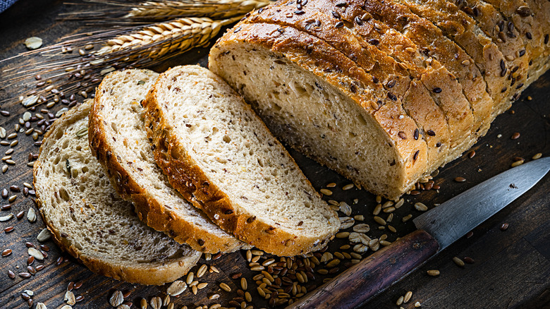 Sliced wheat loaf on board