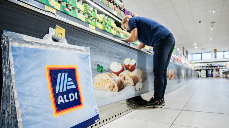 Woman leaning over freezer case at Aldi