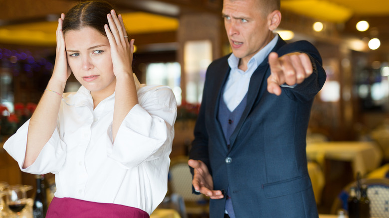 man yelling at stressed waitress