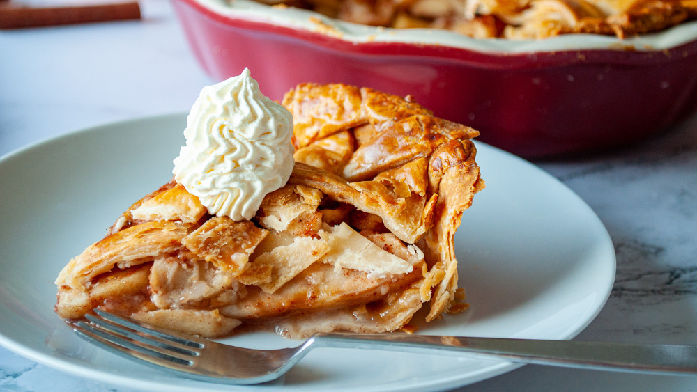 apple pie with whipped cream and fork