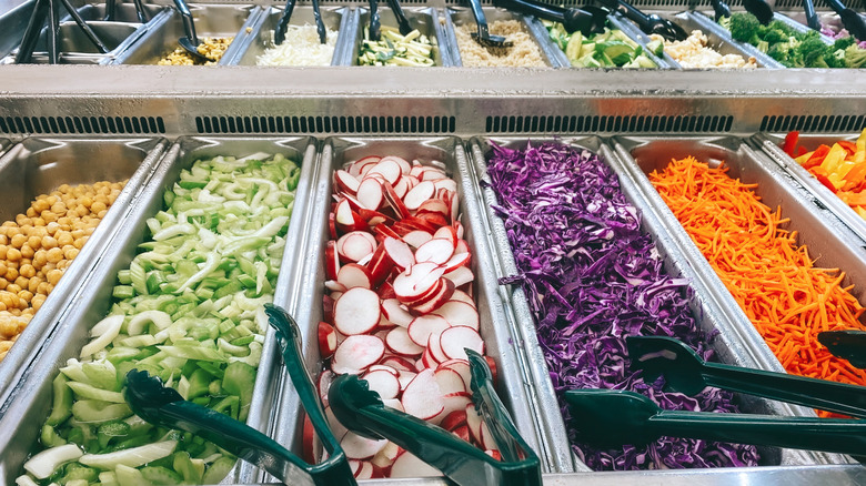 Fresh salad bar with tongs