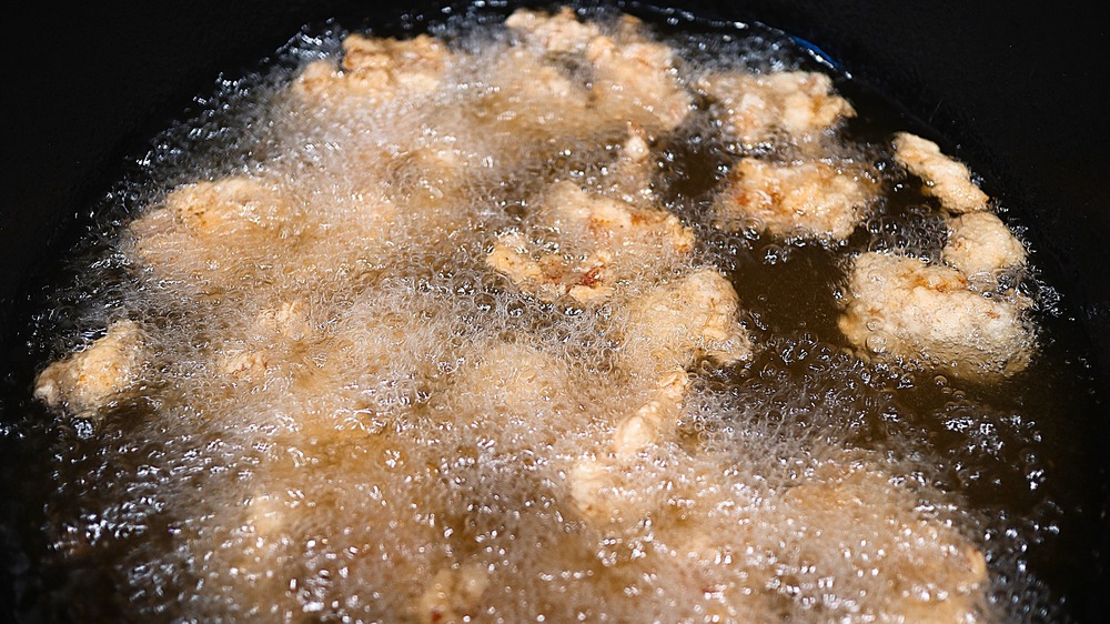 frying chicken in dark pot