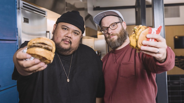 Seth Rogen and Alvin Cailan holding up burgers