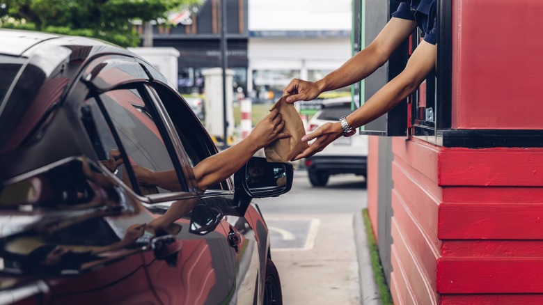 Worker handing order to customer 