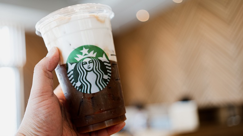 Hand holding coffee with cold foam