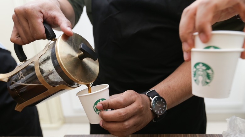 pouring coffee into Starbucks cups