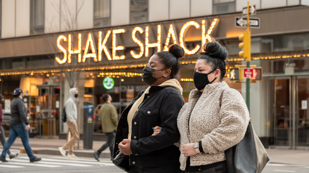 People walking in front of Shake Shack