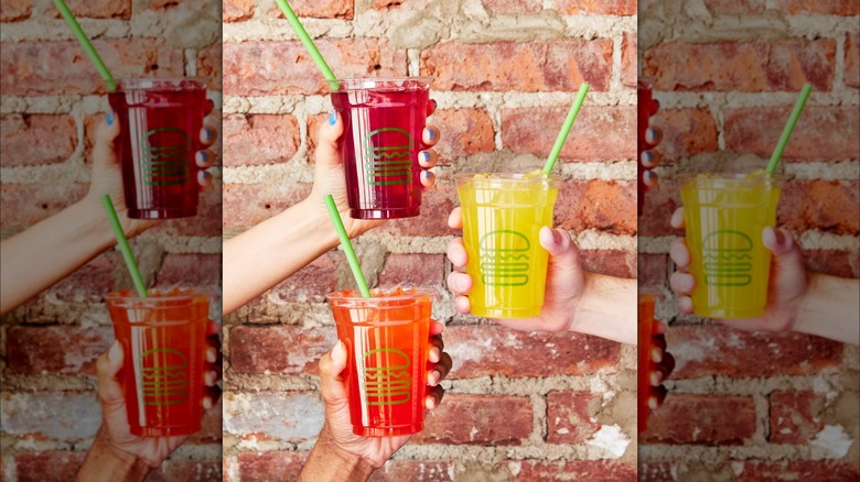 Hands holding Shake Shack lemonades