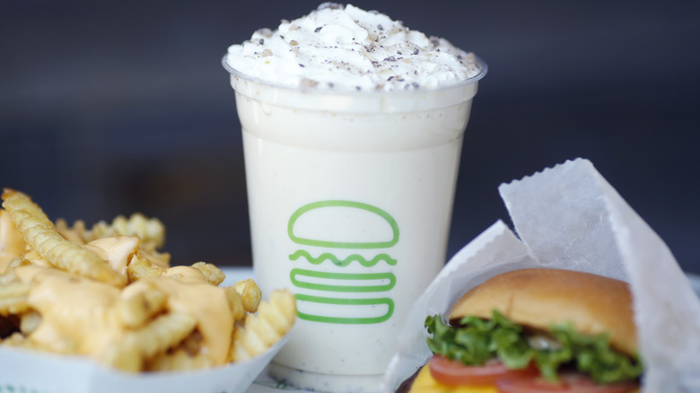 Shake Shack meal with a milkshake in the center and fries and a burger on the sides