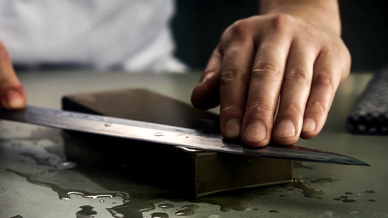 person sharpening a knife