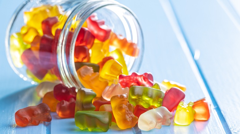 Multi-colored gummy bears pouring from jar