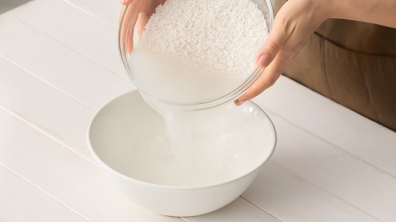 person washing rice in bowl