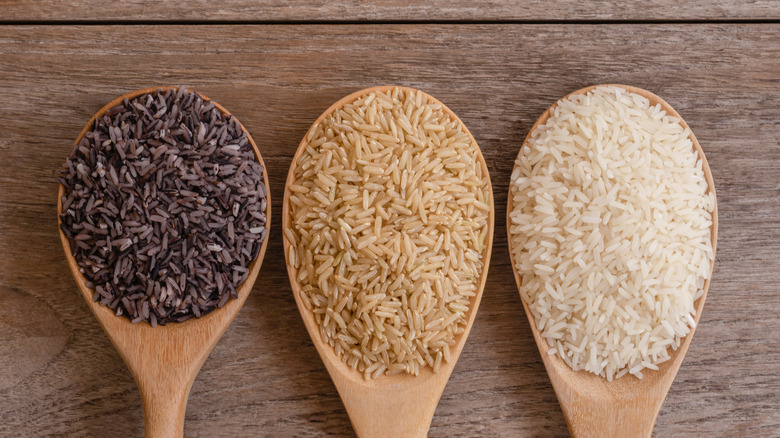 three types of rice on wooden spoons