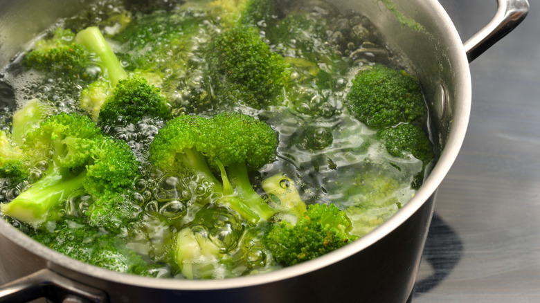 closeup of broccoli blanching in silver pot