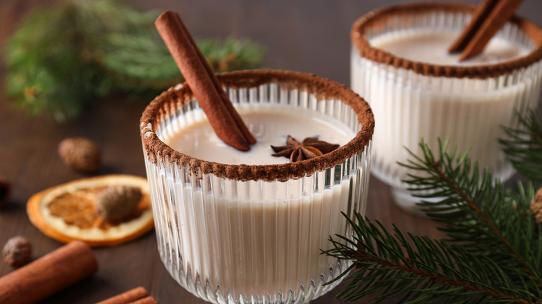 Two glasses of eggnog liqueur with a cinnamon rim in a festive setting