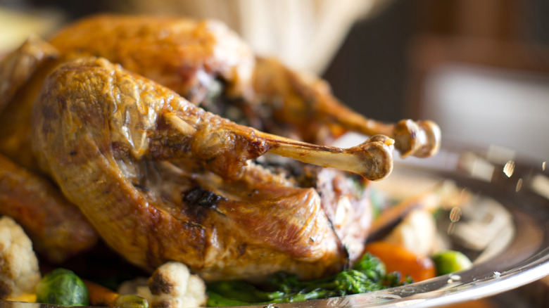 Thanksgiving turkey on a silver plate with vegetables