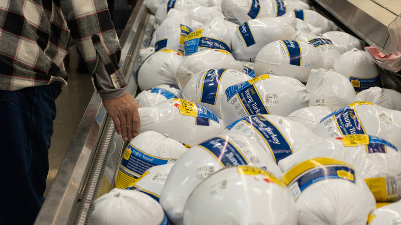 Customer picking out a turkey from a Costco display