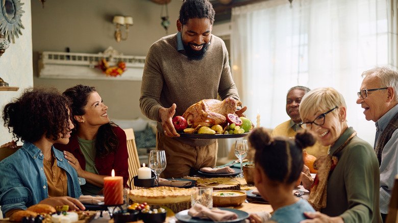 Group of people sitting down to Thanksgiving dinner