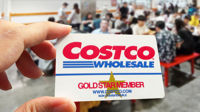 Hand holding a Costco membership card