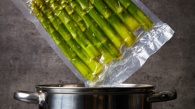 Vacuum-sealed asparagus above metal pot