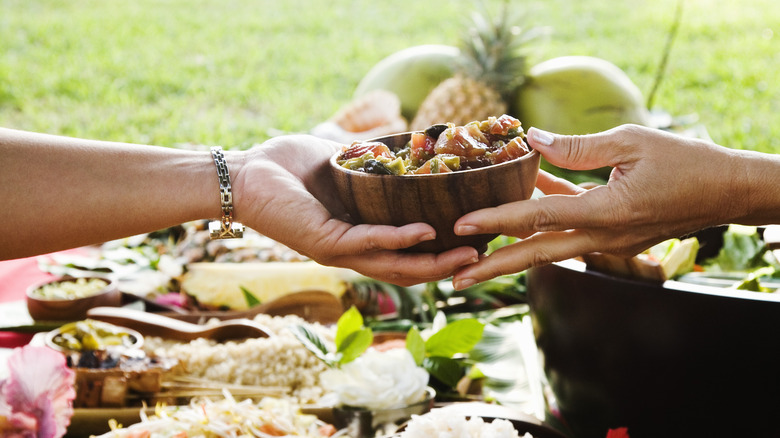 hands passing food bowl