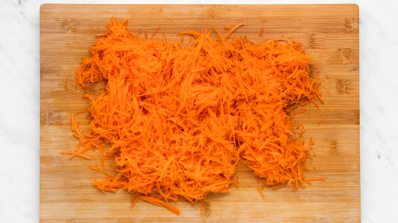 shredded carrots on cutting board 