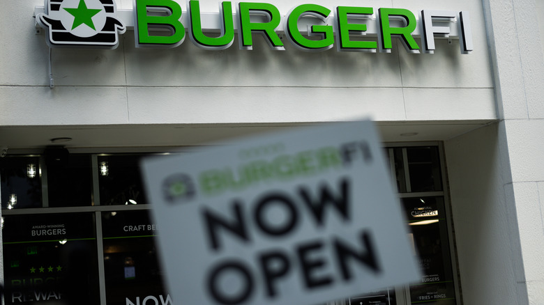 exterior of a burgerfi store with now open signage